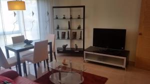 桑亨霍Apartamento Carabuxeira 1的客厅配有电视和桌椅