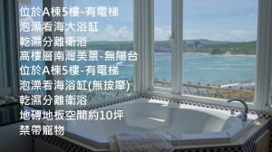 南湾南灣飯店 Kenting Nanwan Hotel的窗户前设有带浴缸的浴室