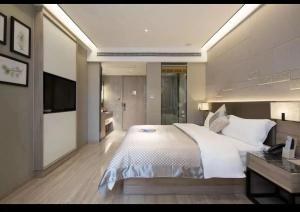 东西湖莫林酒店武汉金银湖园博园裕亚银湖城店的卧室配有一张白色大床和电视。