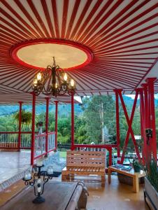 圣罗莎德卡瓦尔Hotel Rural SAN REMO的一间客厅,配有大型红色天花板和长凳