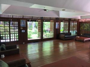 奈汉海滩Baan Krating Phuket Resort -SHA Plus的大型客厅铺有木地板,设有窗户。