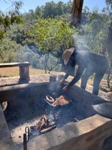 圣萨尔瓦多德朱Cabaña La escondida - JuJuy-的一个人在烤架上的火上做饭