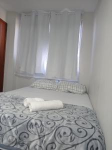 里约热内卢KITNET MOBILIADA - PENHA的一张带毛巾的床,带窗户