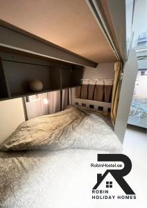 迪拜Robin Beach Hostel JBR的一间卧室配有一张带艾克森度假屋标志的床