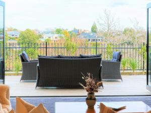 汉密尔顿Wonderful River View-Brand New Home - 4 Bedrooms的木质甲板上配有柳条家具的庭院