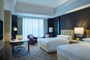 株洲株洲美的万豪酒店的酒店客房配有两张床和一张书桌