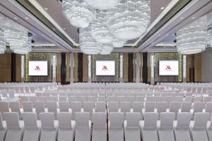 株洲株洲美的万豪酒店的一间会议室,配有白色的椅子和两个屏幕