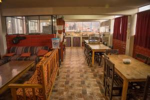瓦拉斯Aldos Guest House的一间带木桌和长椅的餐厅以及一间配有桌子的房间
