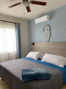 普拉亚卡门Departamento en Riviera Maya的一间卧室配有一张大床和吊扇