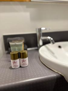 奥克兰Gamma Hotel的两瓶保湿器放在盥洗盆旁的浴室台上