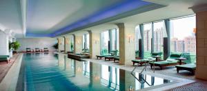 北京北京丽思卡尔顿酒店的一座大型游泳池,位于一座带窗户的建筑内