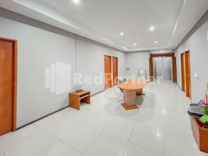 万隆Sang Surya GuestHouse Syariah Near RS Hasan Sadikin Mitra RedDoorz的一间拥有白色墙壁和桌椅的房间