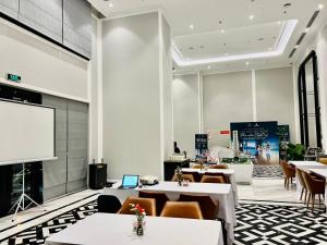 归仁Altara Apartment Quy Nhon的餐厅设有桌椅和投影屏幕