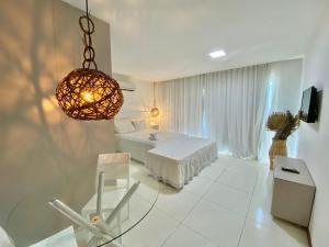 马塞约Bangalô Villas do Pratagy 1 Dormitório e Varanda的一间白色的大房间,配有一张床和吊灯