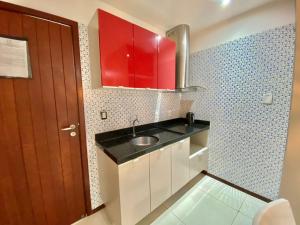 马塞约Bangalô Villas do Pratagy 1 Dormitório e Varanda的一个带水槽和红色橱柜的小厨房