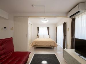 宜野座Dolcevita的一间卧室配有一张床、一张沙发和一台电视。