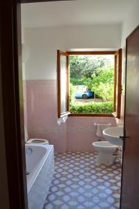 马西亚娜马里纳La Limonaia的一间带两个卫生间、浴缸和窗户的浴室
