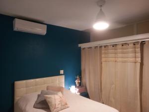 辛普森湾Chambre d'hôte chez Aurélie et Jean-Christophe的一间卧室设有一张床和蓝色的墙壁