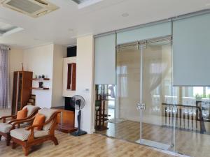 美奈Villa Mui Ne Phan Thiet SeaView的客厅里设有玻璃淋浴间和椅子