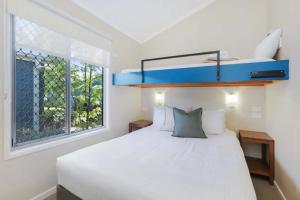 布伦瑞克黑兹Reflections Brunswick Head - Holiday Park的卧室配有白色的床和窗户。
