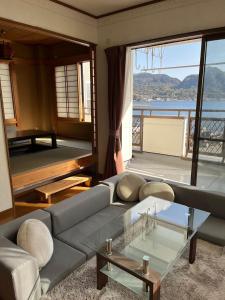 沼津Kitaizu North Private House - Vacation STAY 14216的带沙发和玻璃桌的客厅