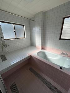 沼津Kitaizu North Private House - Vacation STAY 14216的粉红色的浴室设有浴缸和水槽