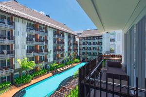 库塔Fairfield by Marriott Bali Kuta Sunset Road的公寓大楼设有游泳池和阳台