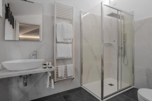蒙特卡蒂尼泰尔梅阿拉西奥酒店的一间带玻璃淋浴和水槽的浴室