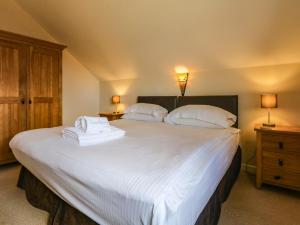 纽基Redwood Lodge, Retallack的卧室配有一张带白色床单和枕头的大床。