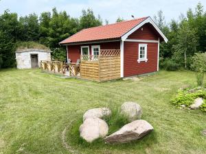 费尔耶斯塔登Newly built cozy cottage on the east side of Öland的一座有岩石的院子中的红色小房子