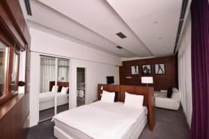 特雷比涅Sesto Senso的卧室配有一张白色的大床和一张沙发。