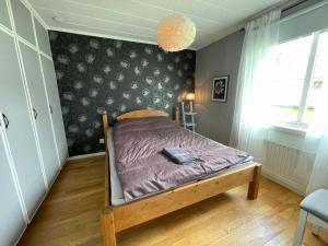 皮特奥Centralt belägen villa i Öjebyn, Piteå的一间卧室配有一张带紫色棉被的床