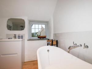 廷塔杰尔Downrow Barn的浴室配有白色浴缸和水槽