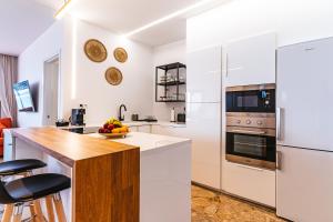 大加那利岛拉斯帕尔马斯1linea Canteras的厨房配有白色家电和木制台面