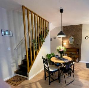 莫雷卢安河Sisley Cottage的一间带桌子和楼梯的用餐室