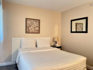 纳奈莫启航湾汽车旅馆的一间卧室配有一张带白色床单的大床