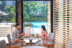 芭东海滩Holiday Inn Express Phuket Patong Beach Central, an IHG Hotel的坐在天井桌子上的男女