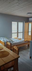 扎托尔Noclegi przy Skawie的客房设有两张床、桌子和窗户。
