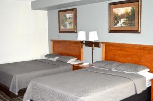 圣克劳德圣克劳德美国最佳价值套房旅馆的酒店客房,设有两张床和两张墙上的照片