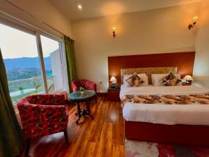 穆索里Hotel Kempty - A Boutique Hotel, Mussoorie的酒店客房带一张床、一张桌子和椅子