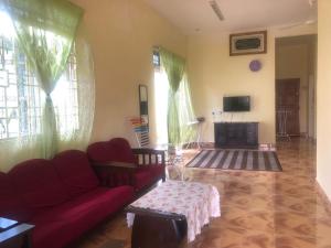 PendangHomestay Seri Hampar, Pendang的客厅配有红色沙发和电视