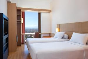万隆宜必思万隆一室公寓酒店的酒店客房设有两张床和电视。