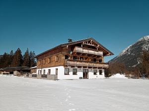 阿亨基希Ferienwohnung Hinterwinkl的一座大木结构建筑,位于雪顶上