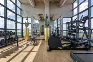恩斯赫德U Parkhotel的一个带跑步机和举重器械的健身房,位于带窗户的房间内
