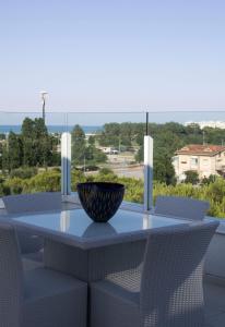 米萨诺阿德里亚蒂科Suite Luxury Seaview的阳台上配有桌椅和碗
