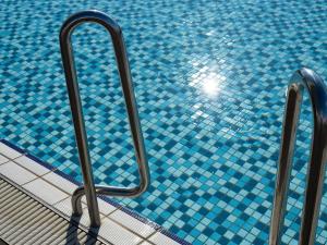 那霸那霸凯悦酒店冲绳的靠近一个蓝色瓷砖的游泳池