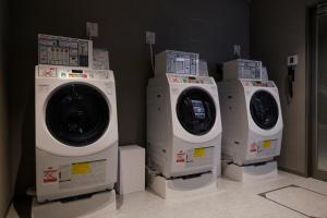 京都THE BLOSSOM KYOTO的房间里的三台洗衣机排成一排