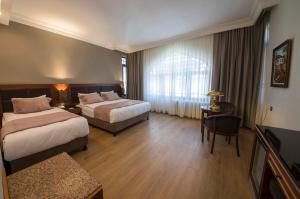伊斯坦布尔瓦尔达尔宫酒店 - 特殊类别的酒店客房设有两张床和一张桌子。