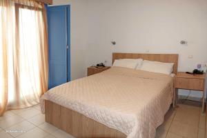 Agía MarínaAerikohotel - Apartments的一间卧室设有一张大床和一扇蓝色的门