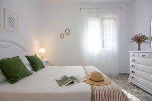 洛斯卡尼奥斯德梅卡CASA DE MECA, a 100m de la playa的一间白色的卧室,配有一张带帽子的床